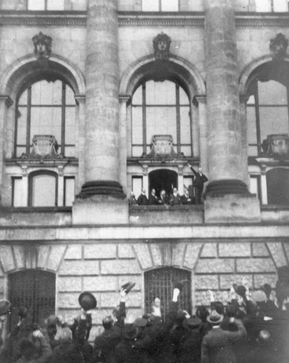 Scheidemann ruft vom Westbalkon (zweites Fenster nördlich des Portikus) des Reichtagsgebäudes die Republik aus. 9.November 1918 (Quelle: Wikipedia, gemeinfrei)